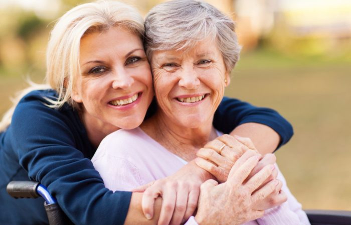 21291088 - cheerful middle aged woman embracing disabled senior mother outdoors