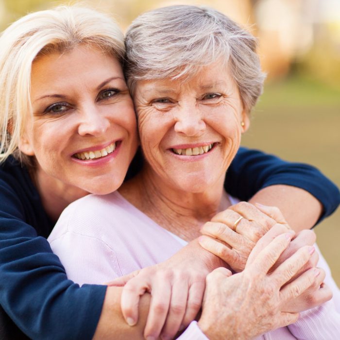 21291088 - cheerful middle aged woman embracing disabled senior mother outdoors